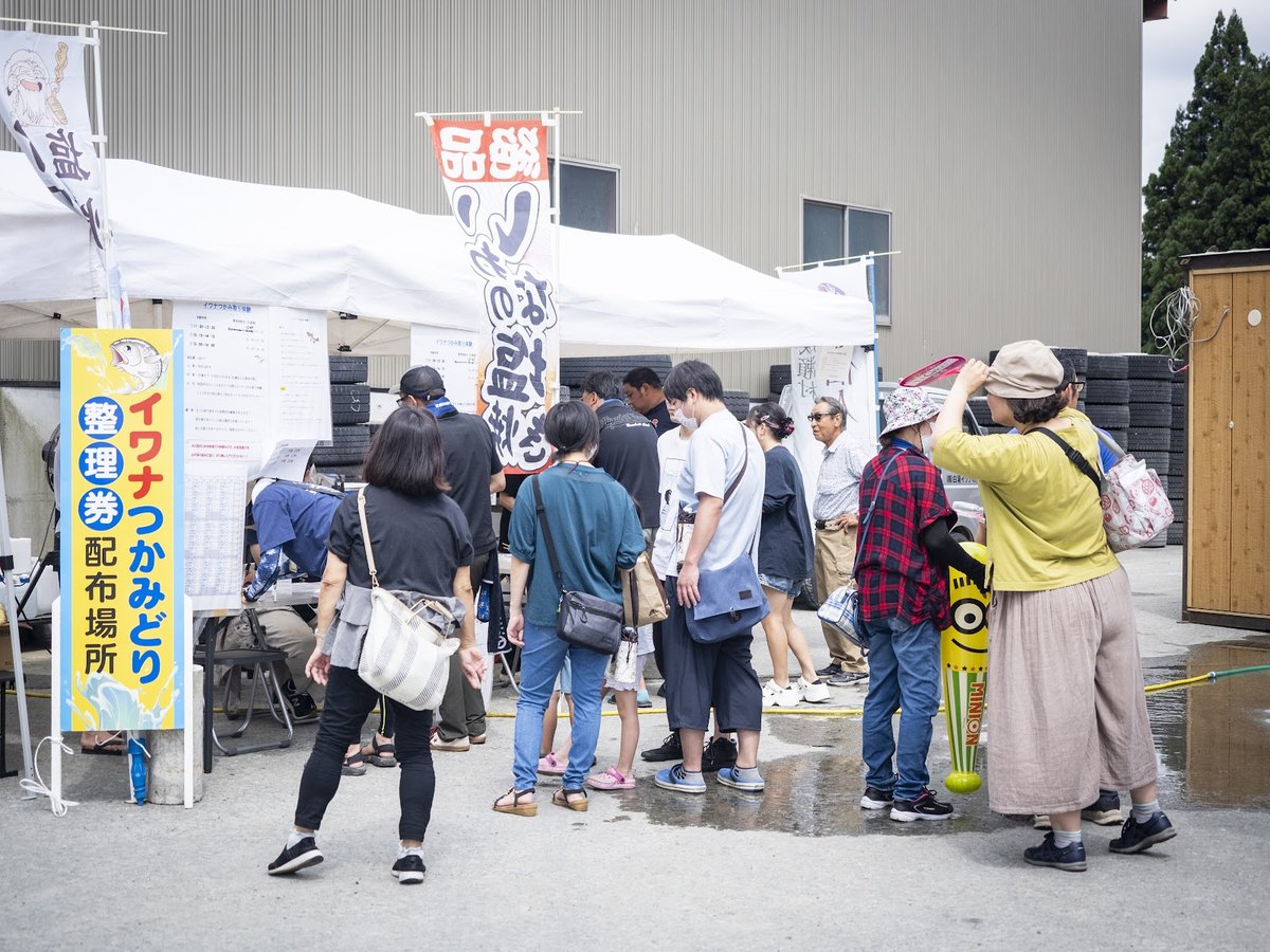 イワナのつかみ取り受付に並ぶ来場者